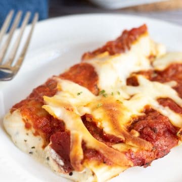 A plate with two cheese stuffed manicotti.