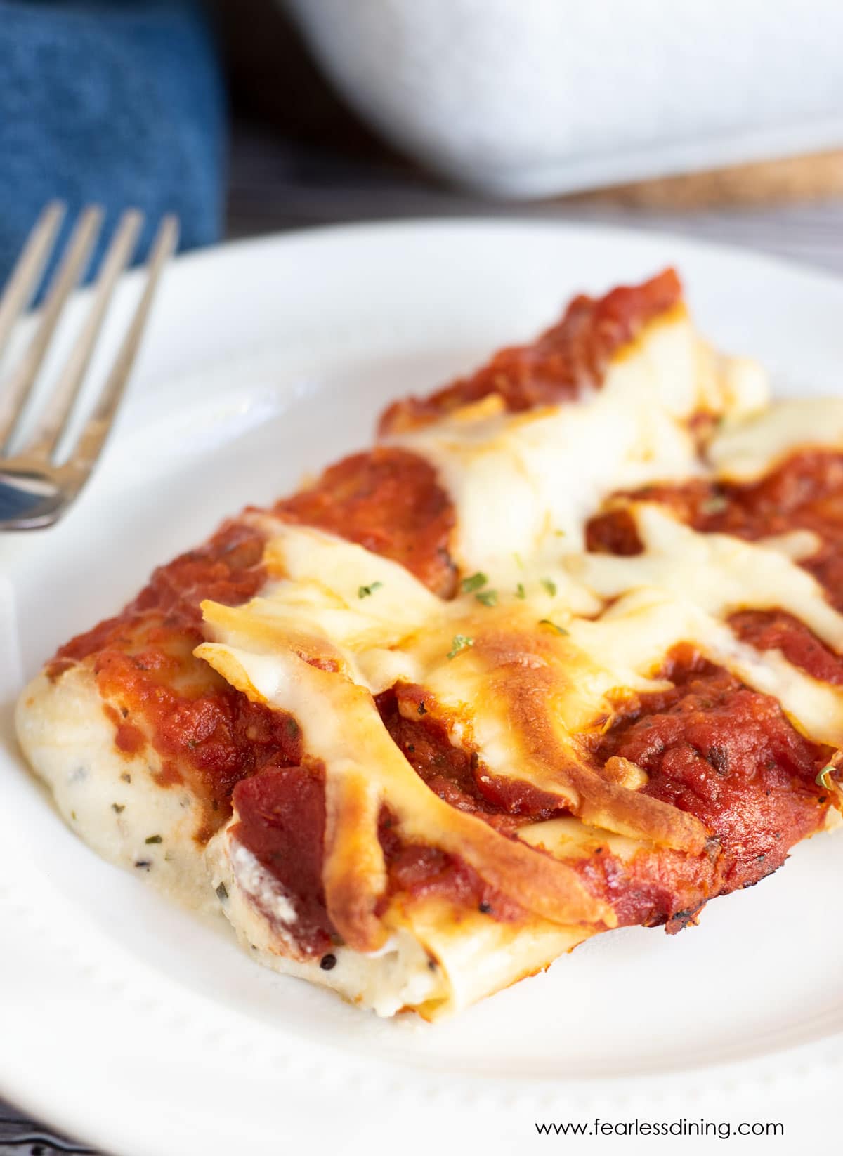 A plate with two cheese stuffed manicotti.