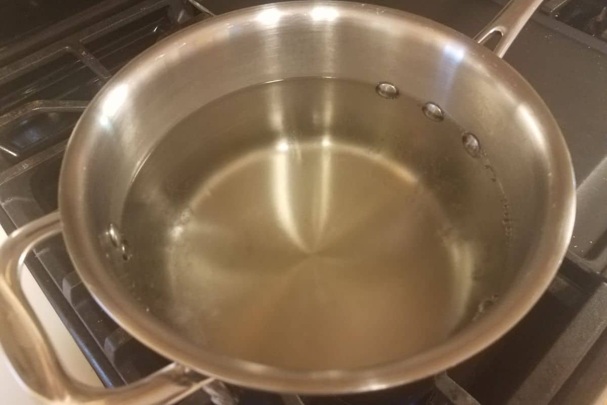 A pot of water and gelatin on the stove.