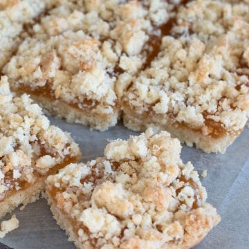 A close up of the cut apricot jam bars on parchment paper.