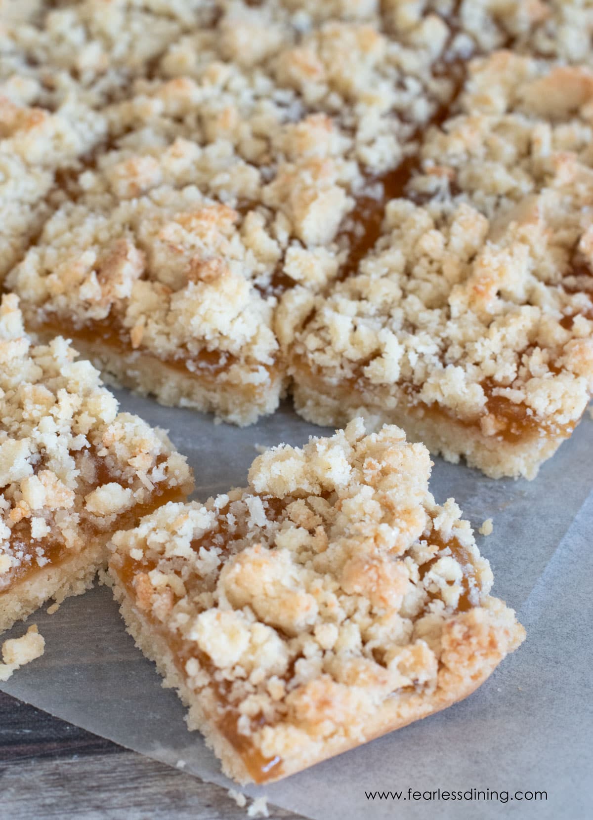 A close up of the cut apricot jam bars on parchment paper.