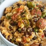 A white serving bowl filled with cajun rice and beans.