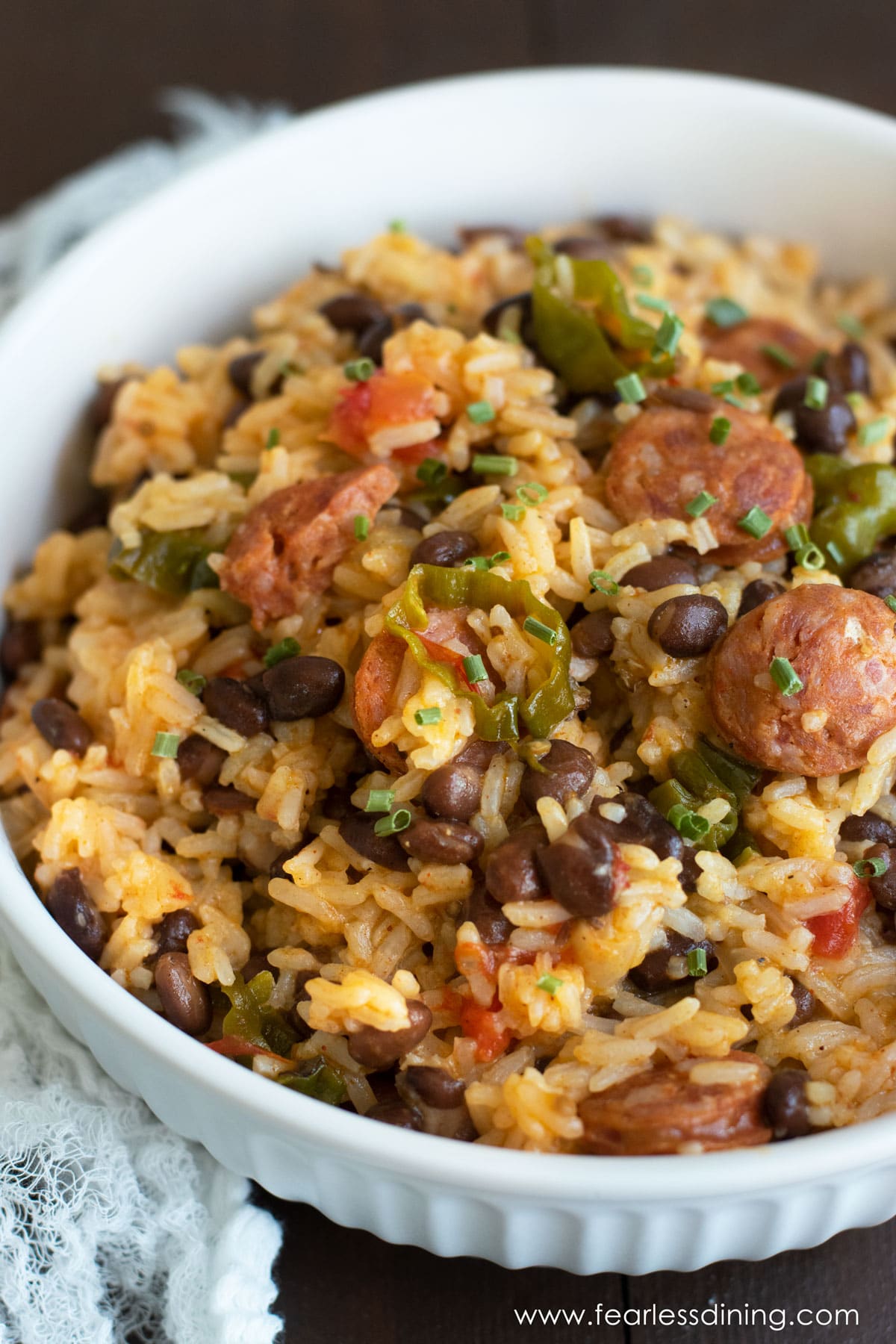 A white serving bowl filled with cajun rice and beans.