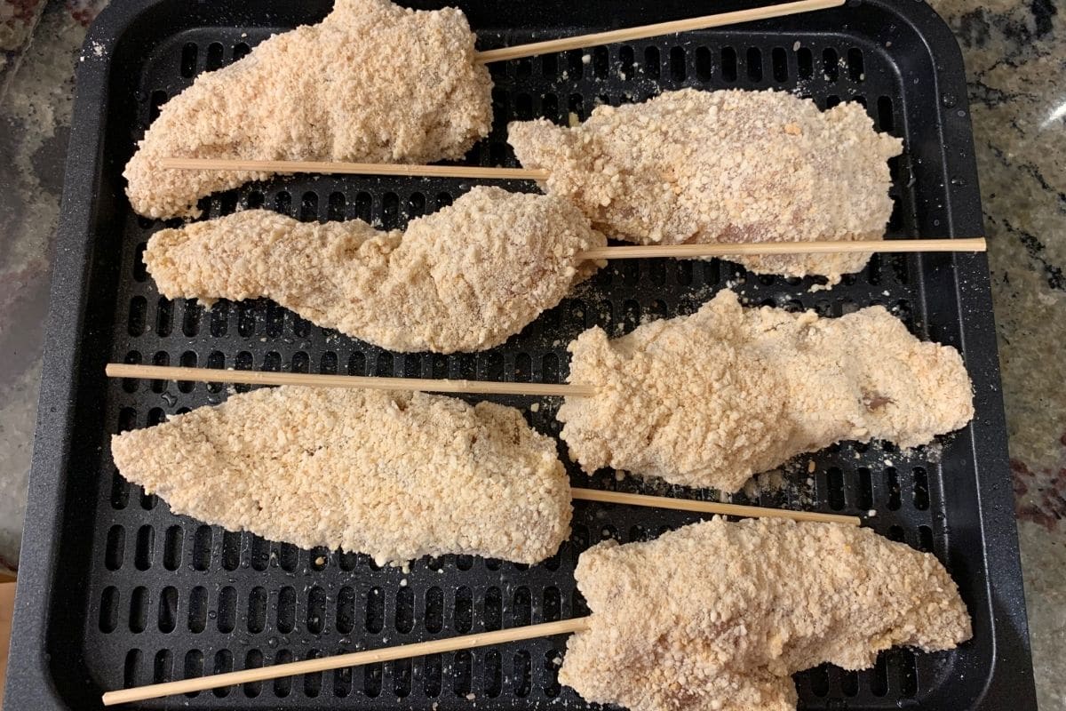 The chicken tenders on a rack ready to air fry.