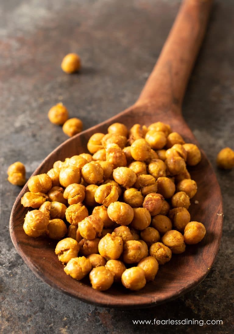 A wooden spoon full of air fried garbanzo beans.