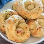 A plate filled with baked garlic knots.