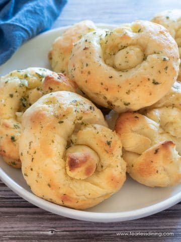 A plate filled with baked garlic knots.