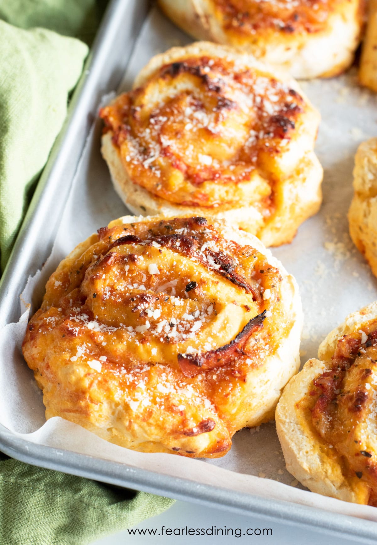 A baking sheet with baked gluten free pizza rolls.