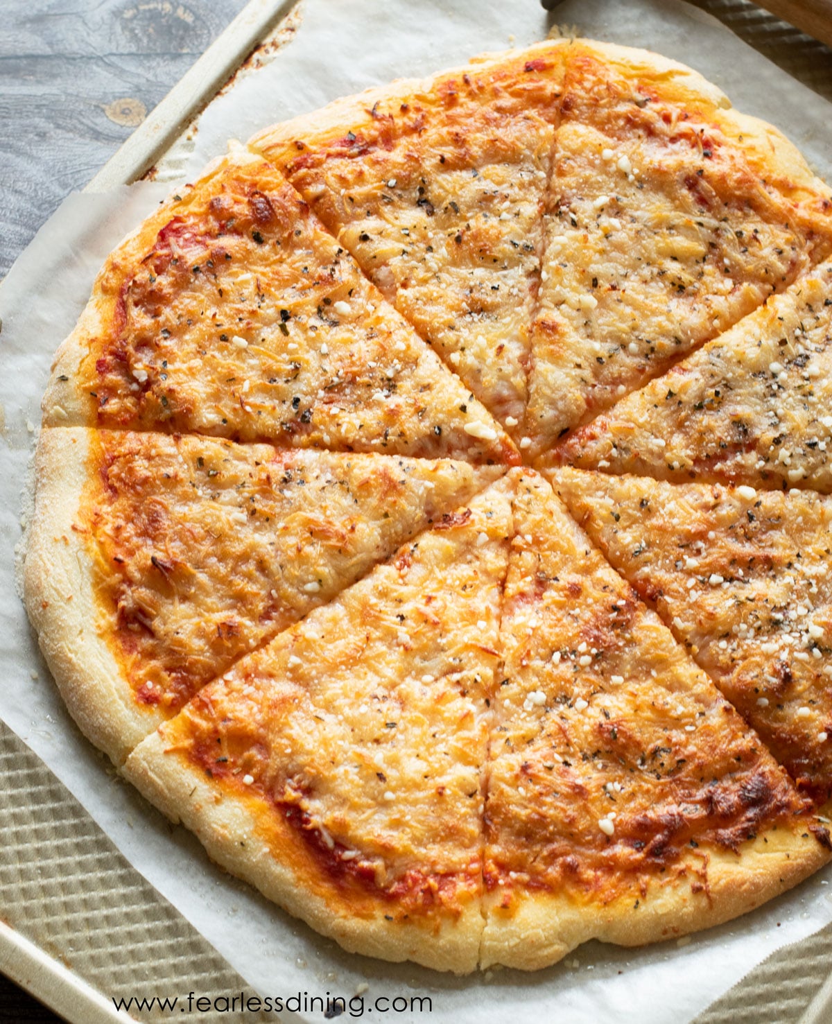 A sliced pizza on a baking sheet.