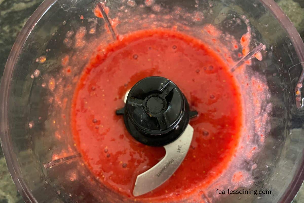 Pureed strawberries in a small food processor.