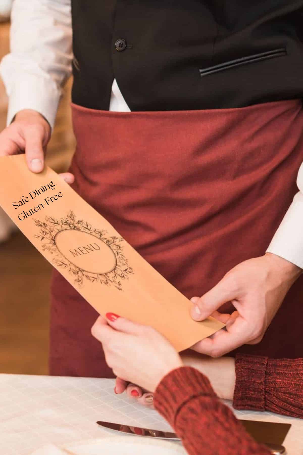 A waiter handing a diner a menu.