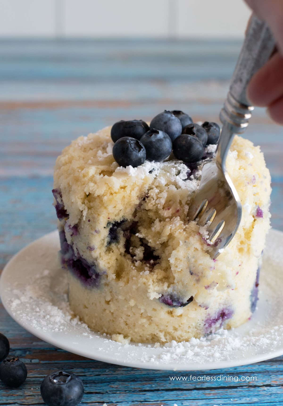 a fork cutting into a blueberry mug muffin