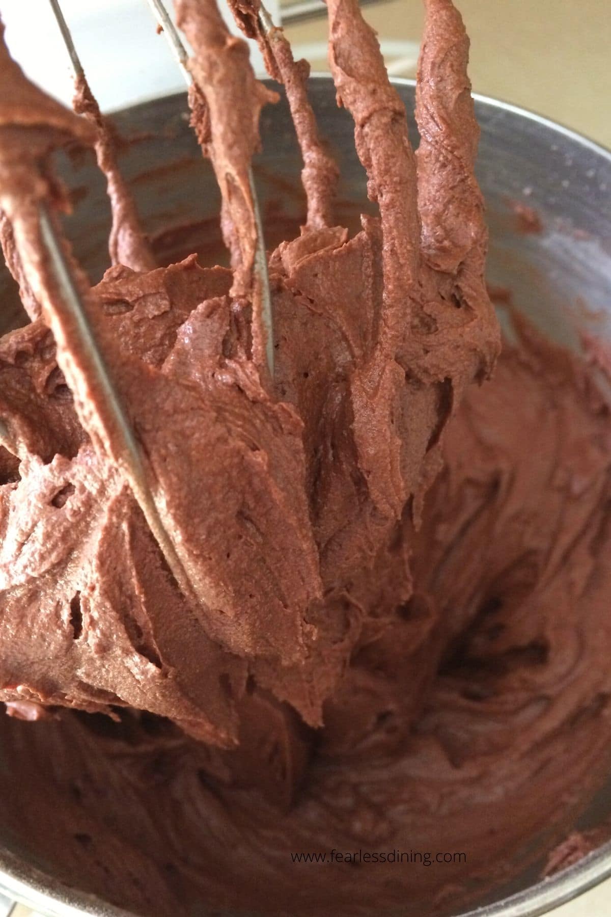 Some chocolate frosting on a whisk attachment.