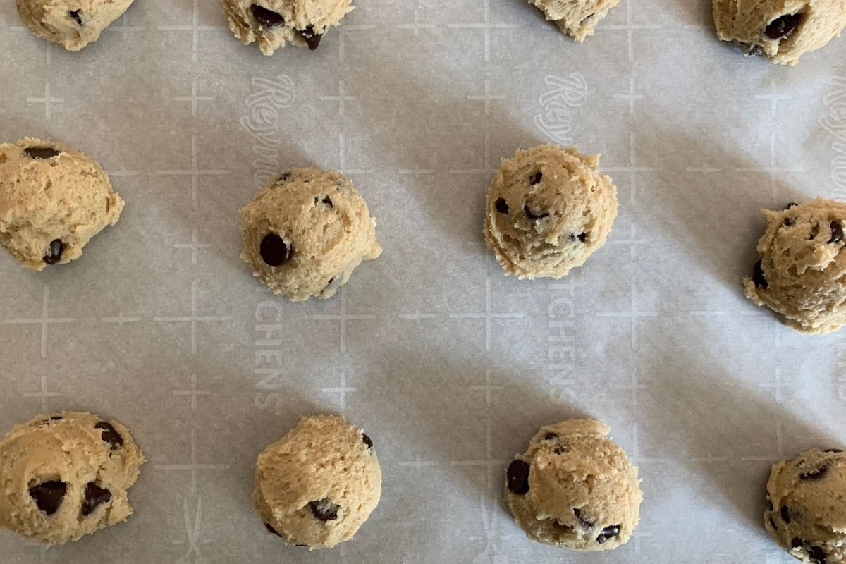 Toll House cookie dough balls on a baking tray.