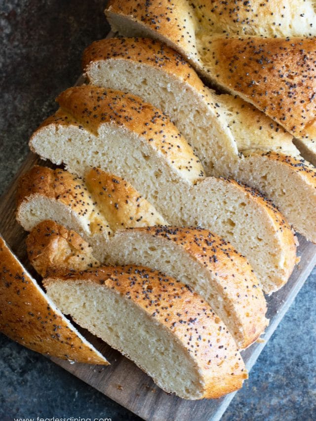 A sliced loaf of gluten free challah on a cutting board.