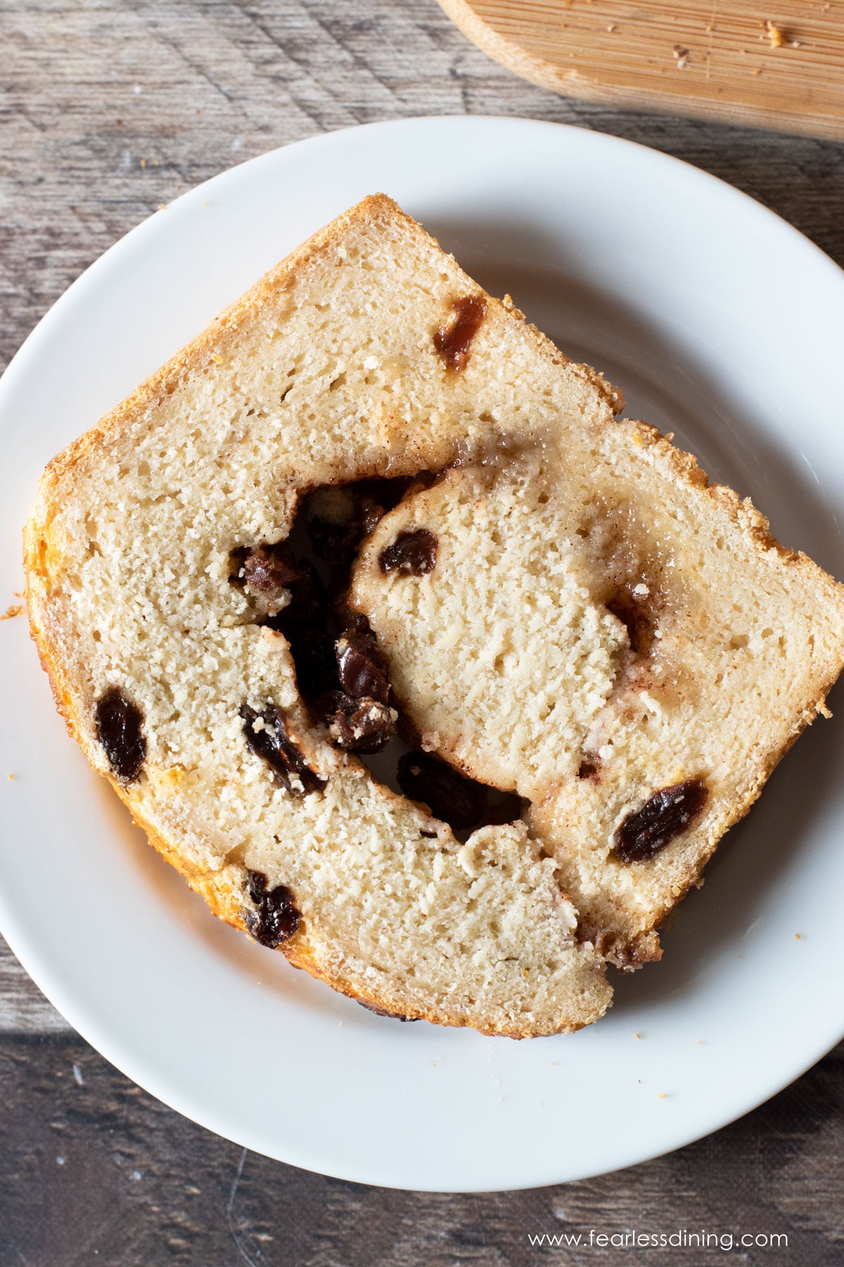 A slice of gluten free cinnamon raisin bread on a plate.