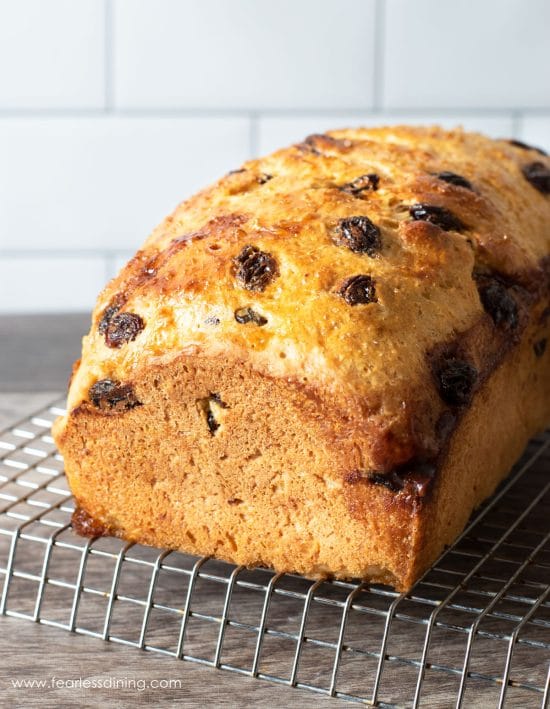A loaf of raisin bread on a wire rack.