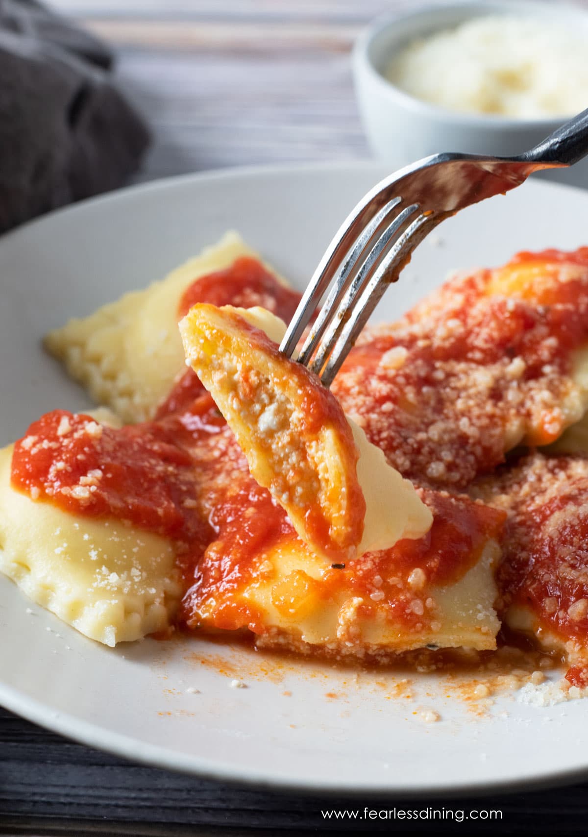 a slice of gluten free ravioli so you can see the ricotta filling inside