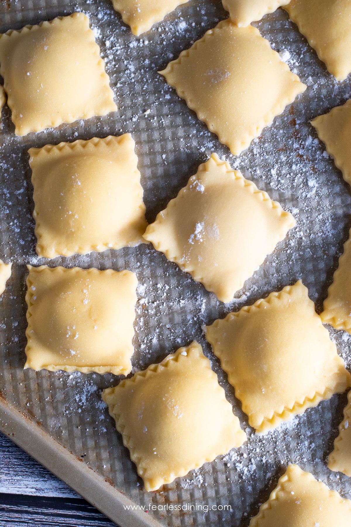 Uncooked ravioli on a tray.