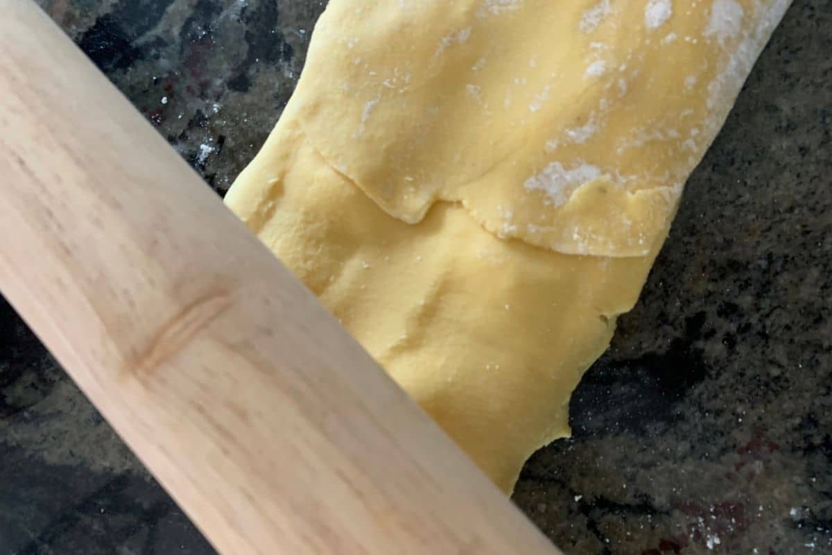 Using a rolling pin to seal the ravioli.
