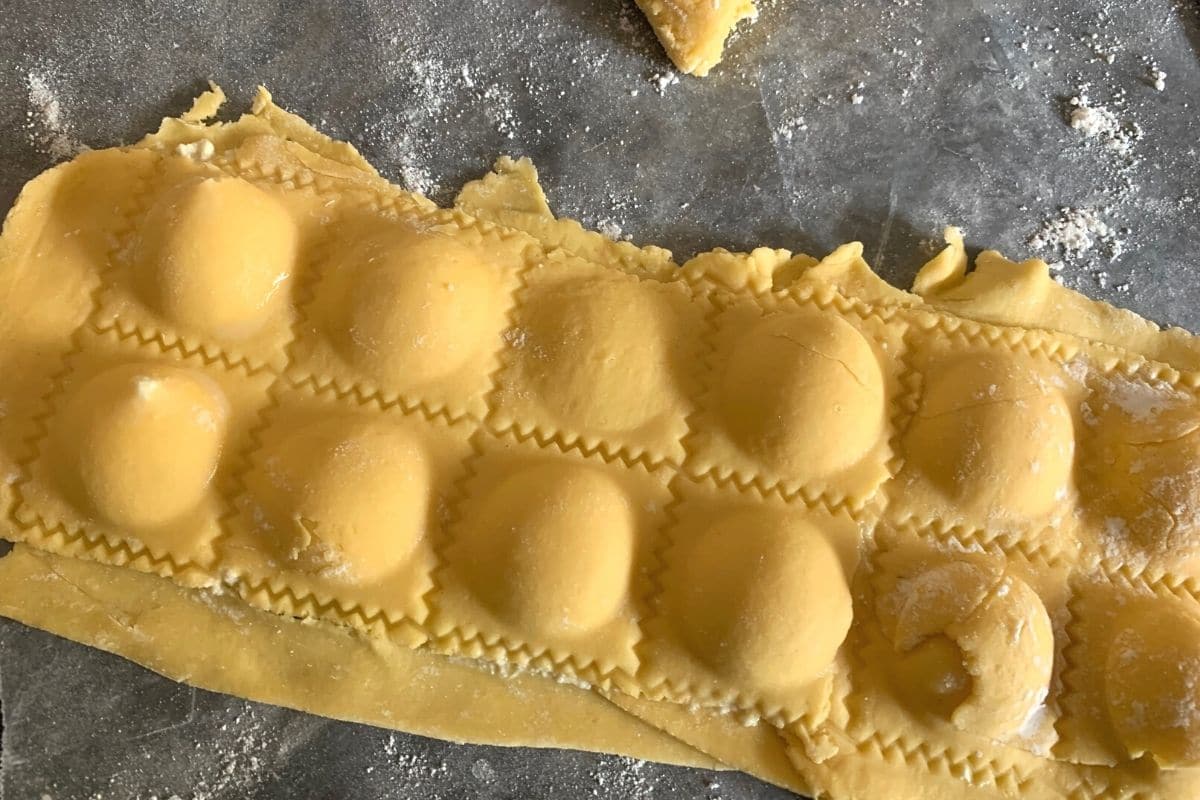 Using a cutter to cut the ravioli apart.