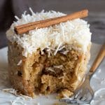 a gluten free carrot mug cake with a slice taken out. It is frosted.