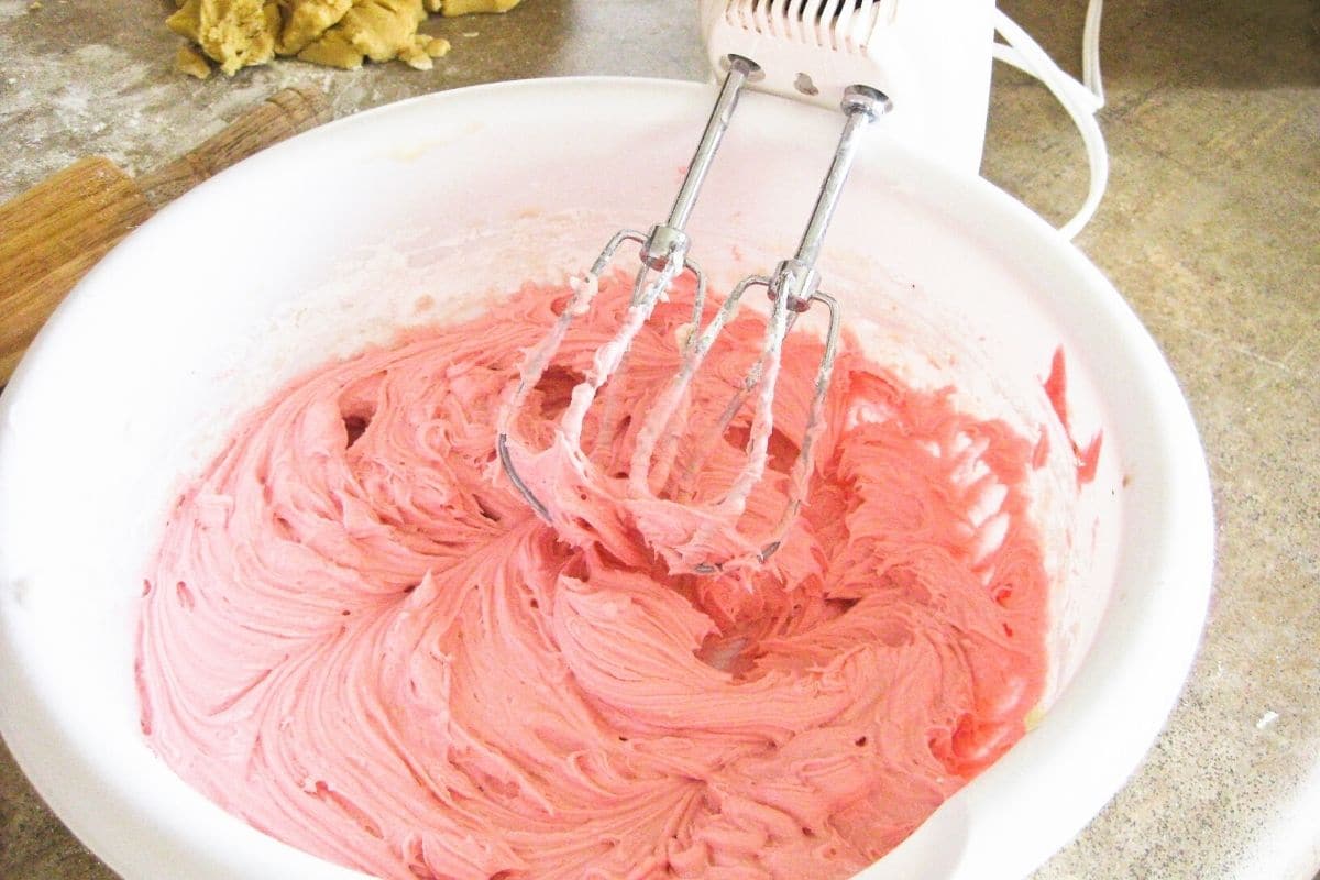 Pink strawberry frosting in a bowl.