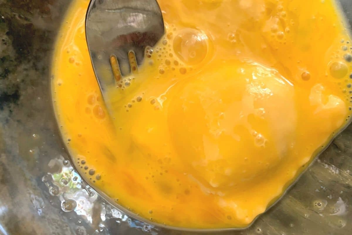 Dipping ravioli in the egg.