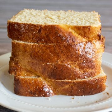 A stack of four slices of brioche on a plate.