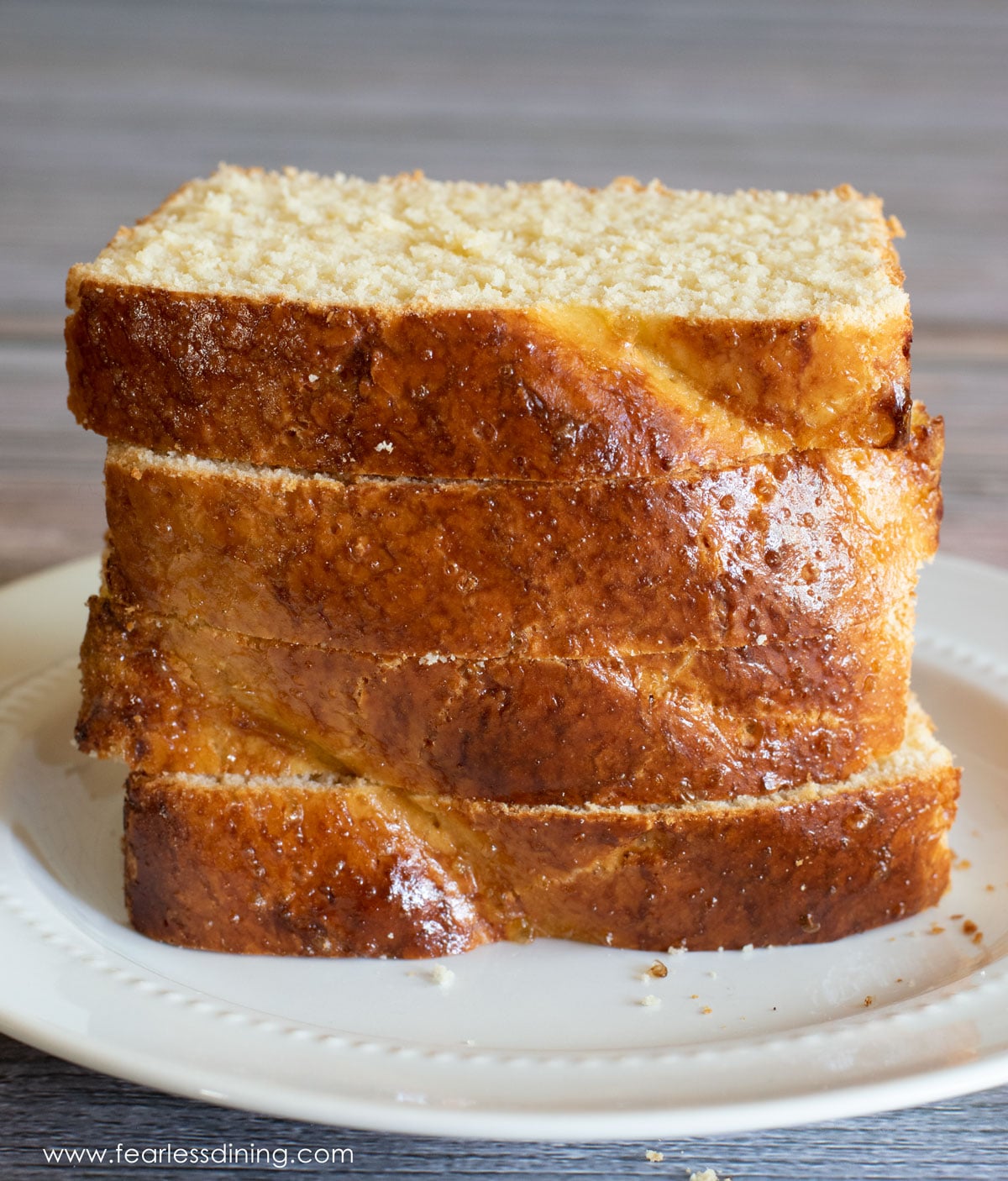 A stack of four slices of brioche on a plate.