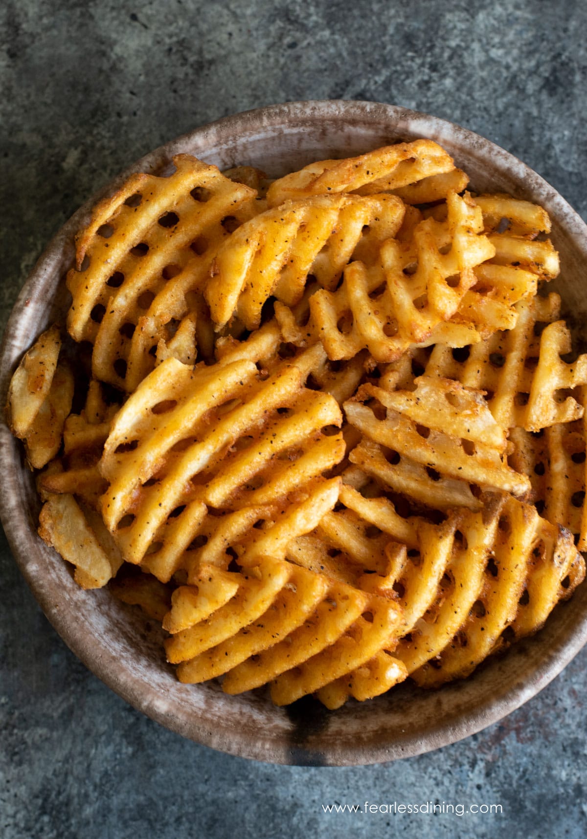 A top view of a large bowl of waffle fries.