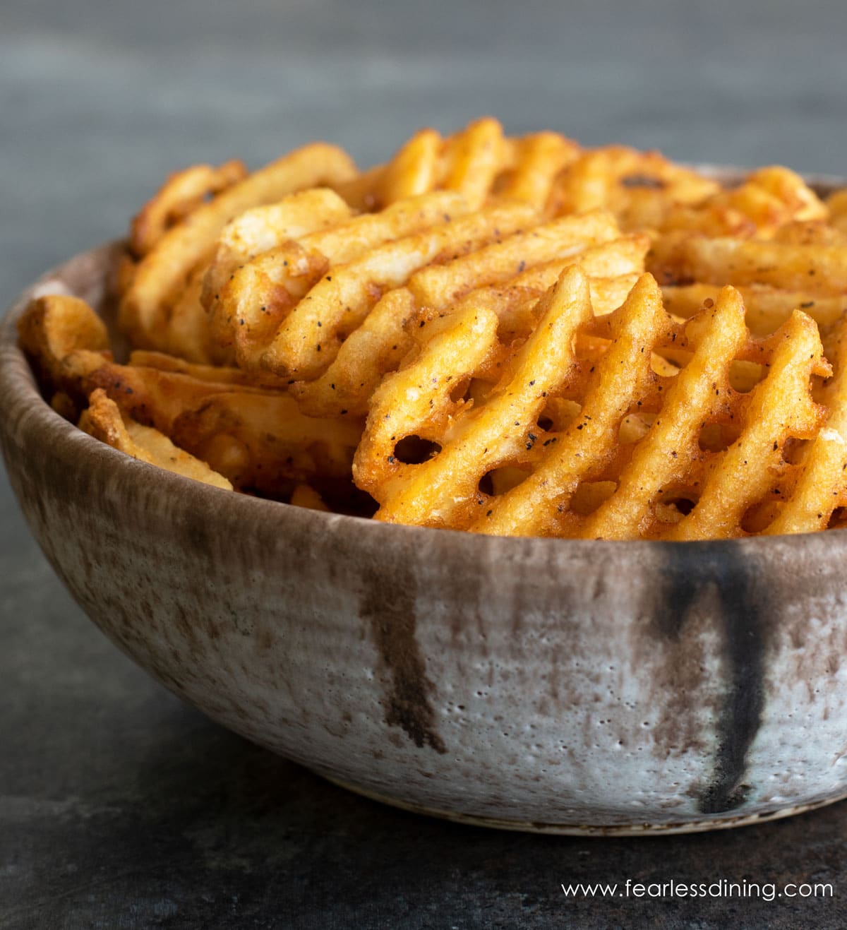 A big bowl of air fryer waffle fries in a bowl.