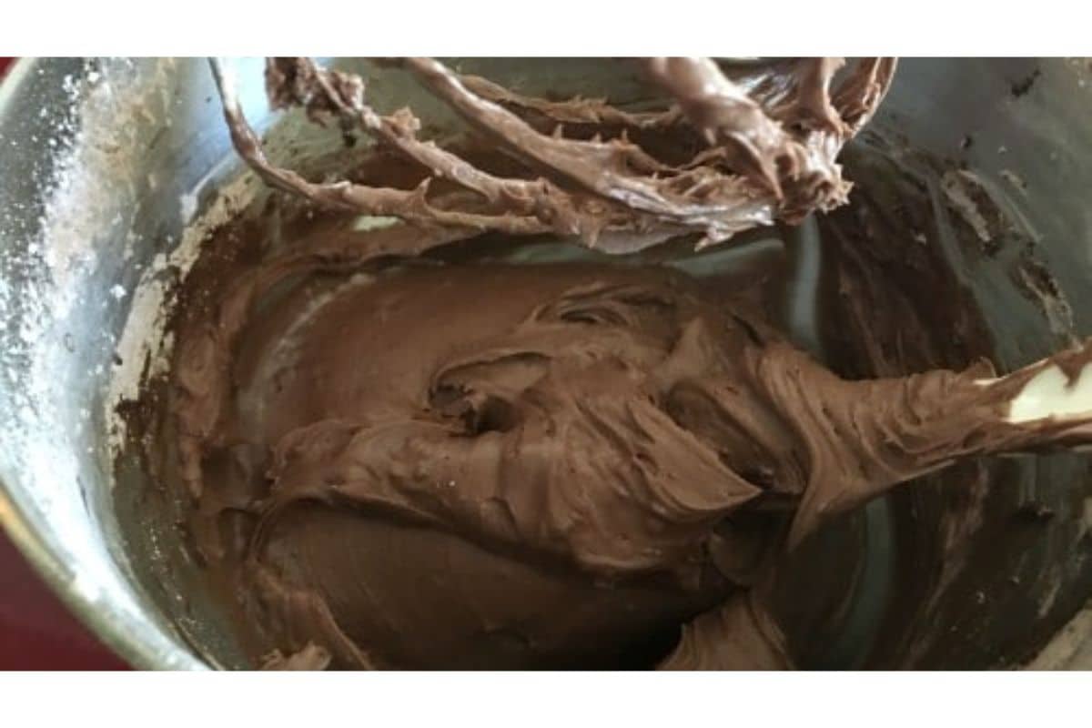 Chocolate frosting in a stand mixer bowl.