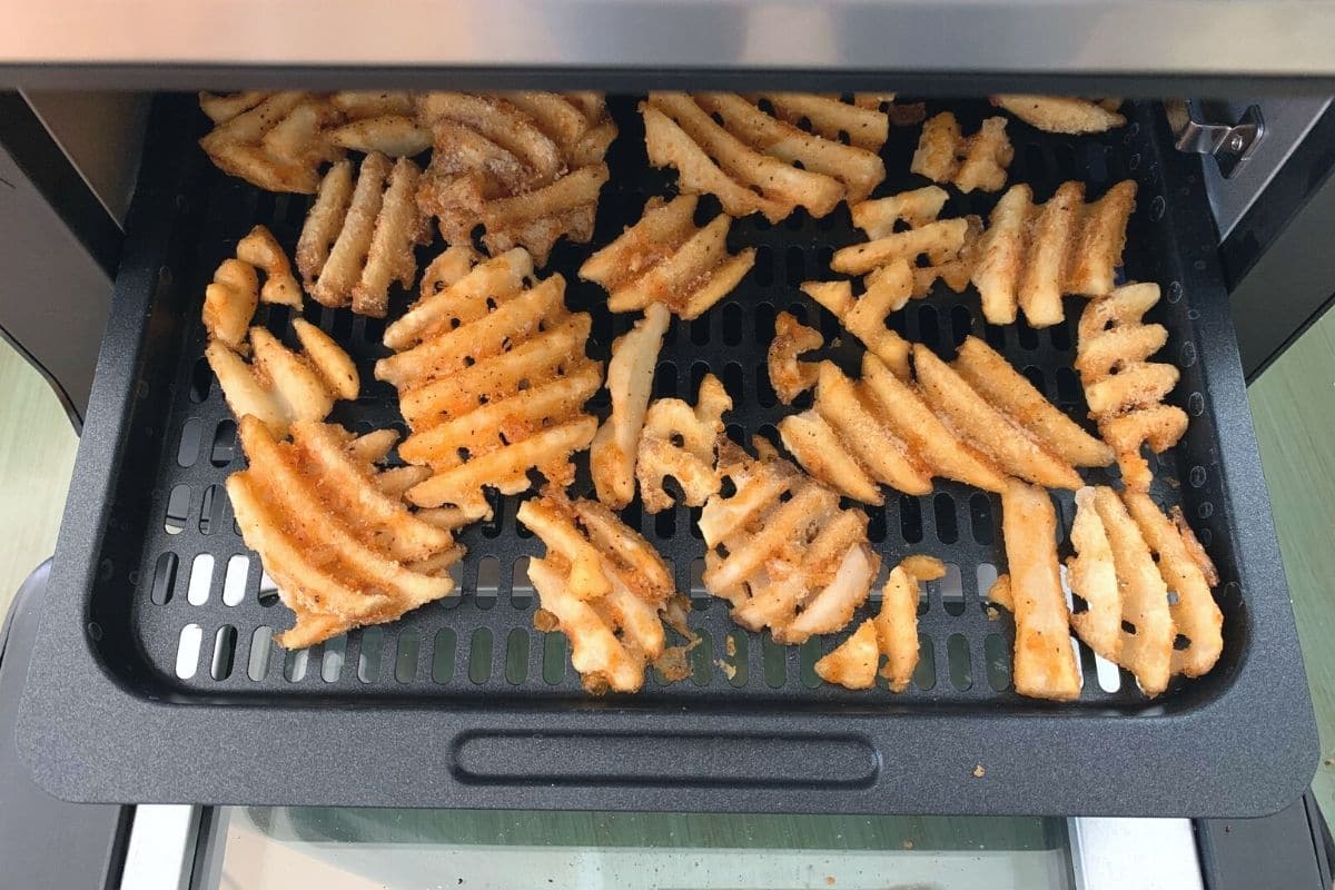 Frozen waffles on a tray in the oven style air fryer.