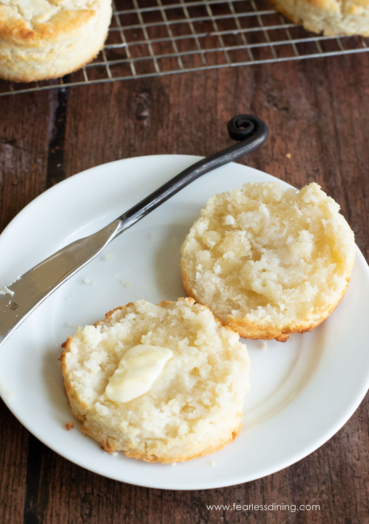 A bisquick biscuit cut open and topped with a butter patty.