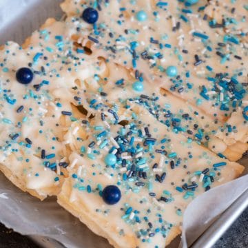 a tray of gluten free matzo crack with white chocolate and blue sprinkles.