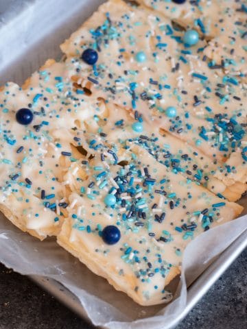 a tray of gluten free matzo crack with white chocolate and blue sprinkles.