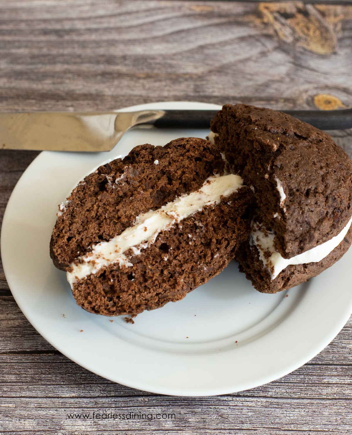 A whoopie pie on a plate that was cut in half.