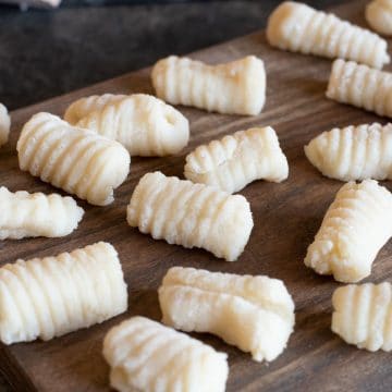 Homemade gluten free gnocchi on a wooden board.