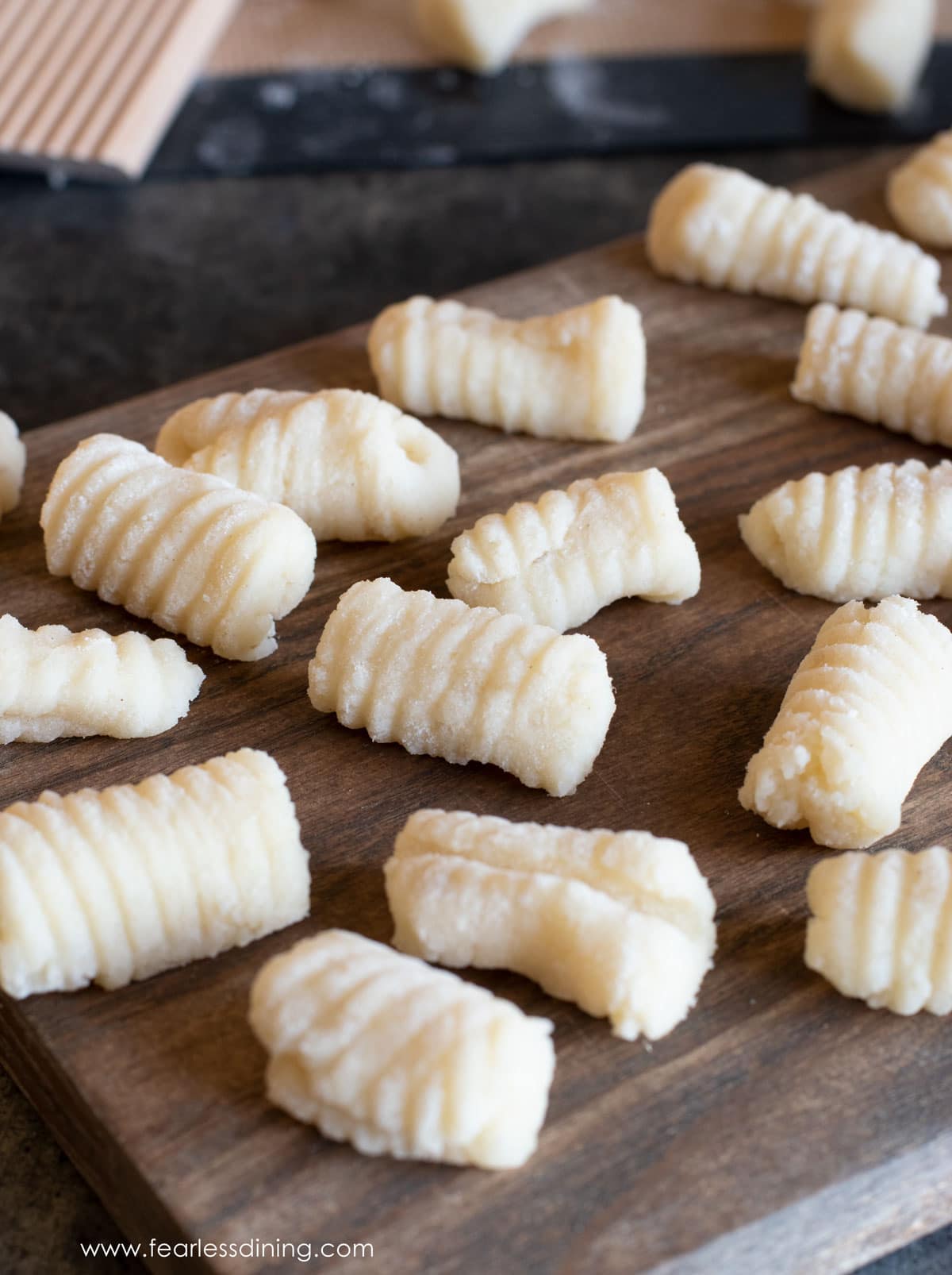 Homemade gluten free gnocchi on a wooden board.