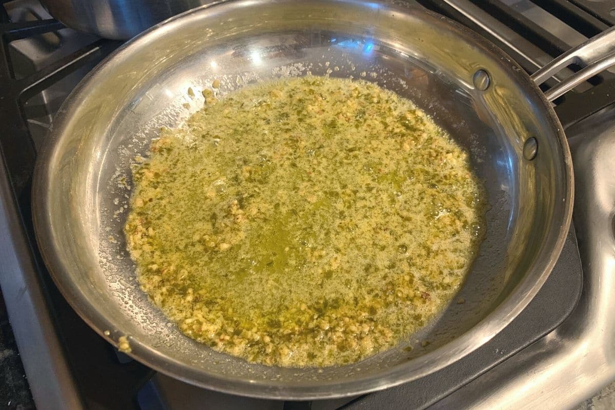 making a simple pesto sauce in a skillet.