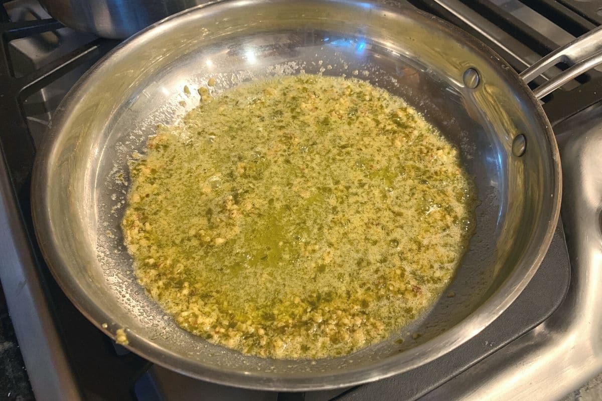 Making a simple pesto sauce in a skillet.