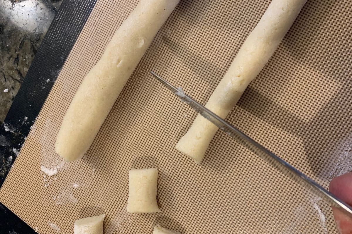 A photo cutting the dough into small sections.