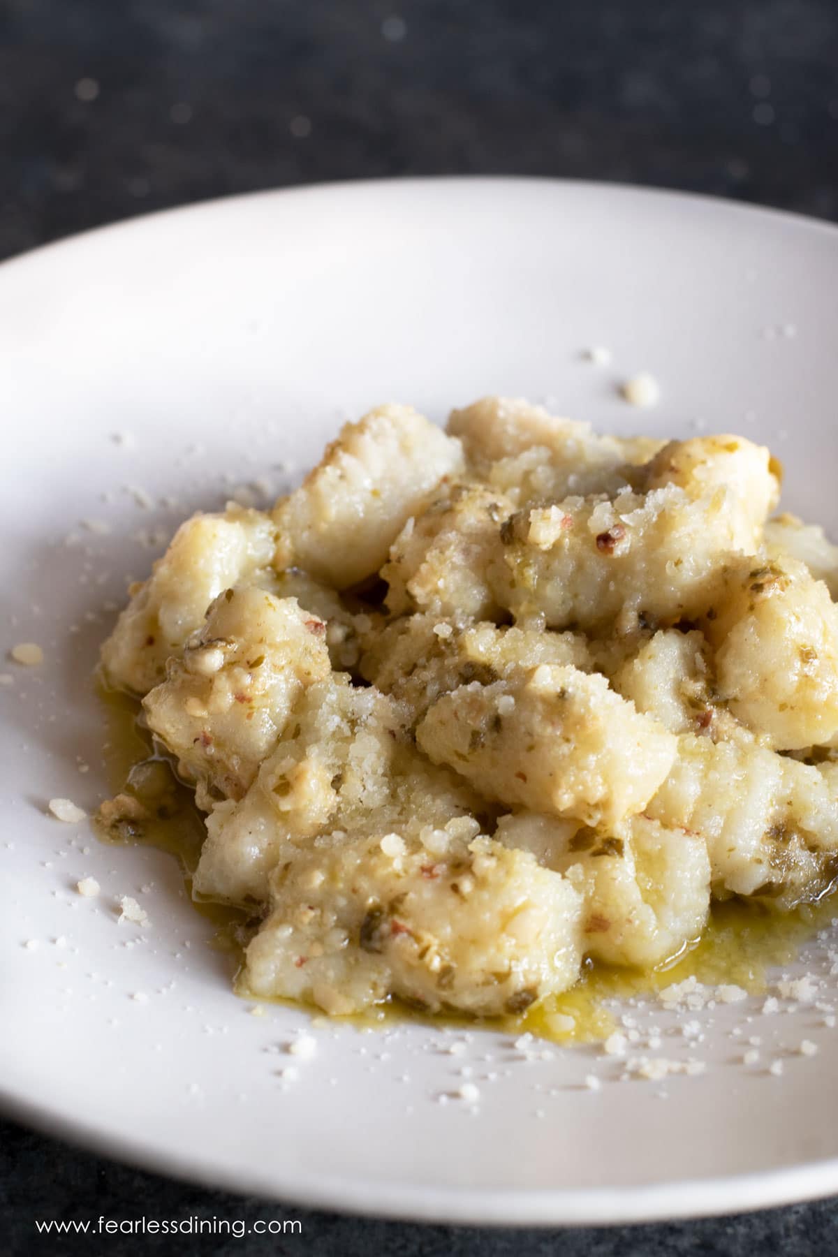 A plate of gnocchi with pesto sauce.