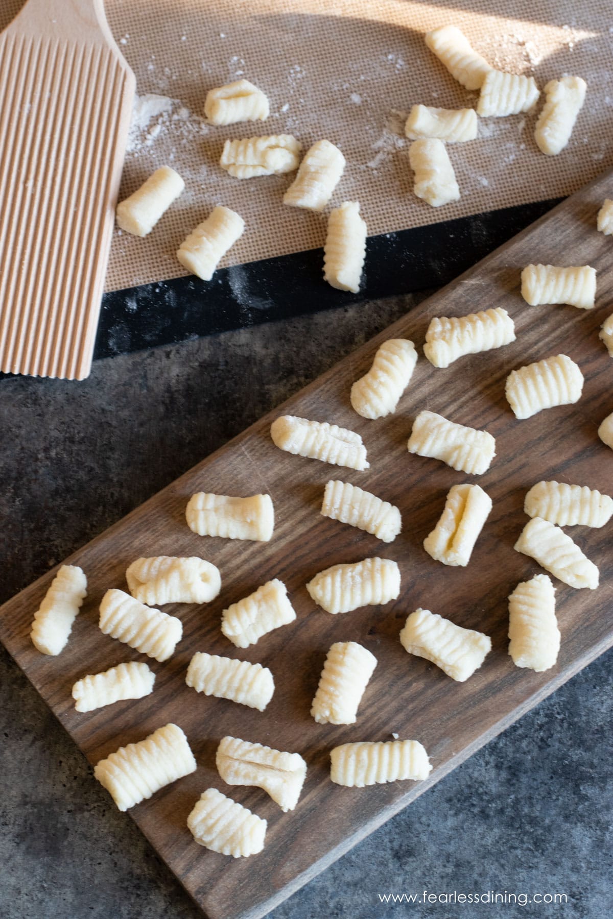 Another photo of the freshly rolled gnocchi on a board.