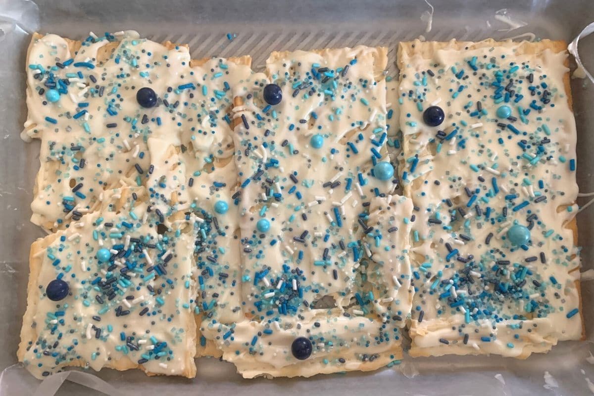 Gluten free matzo with melted white chocolate and sprinkles.