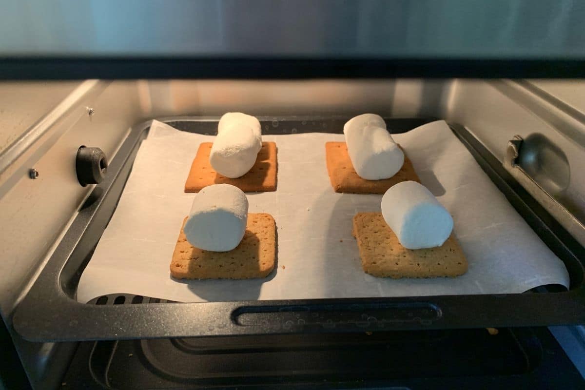 A photo showing the graham crackers with marshmallows on top in the air fryer.