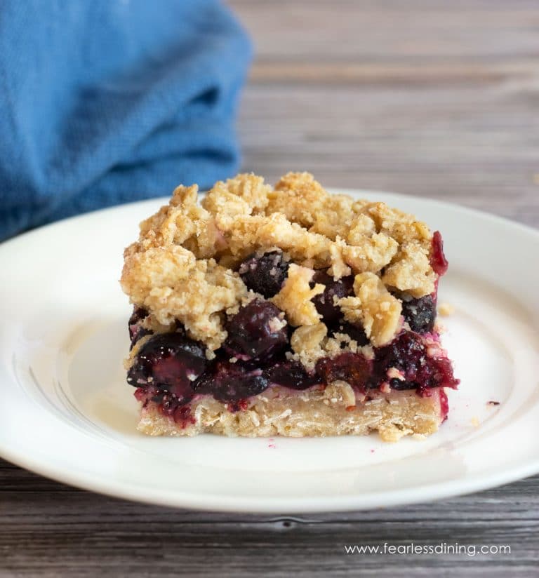 A slice of gluten free blueberry crumble bar on a plate.
