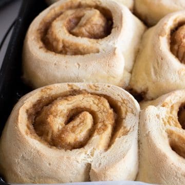 Fully baked cinnamon rolls on a baking sheet.