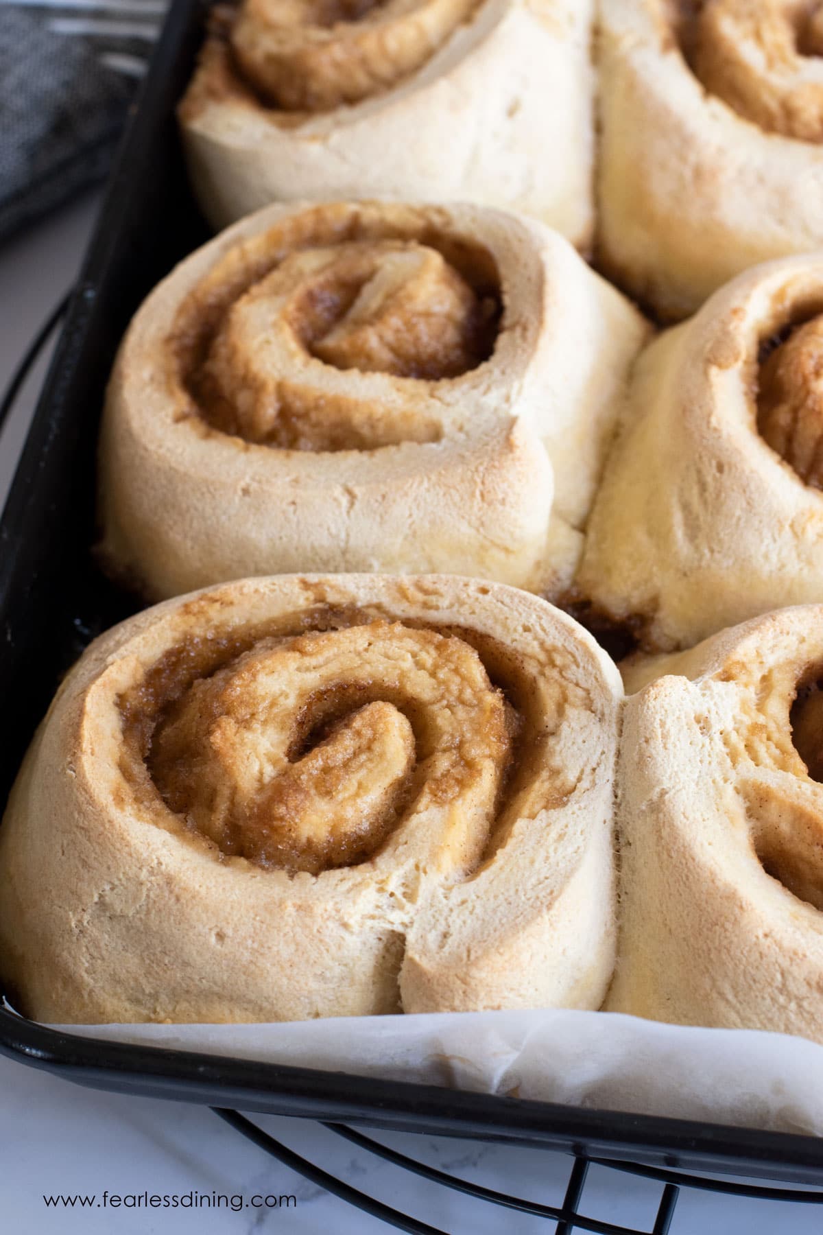 Fully baked cinnamon rolls on a baking sheet.